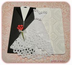 wedding card with white lace and red flower on it's lapel, next to an envelope