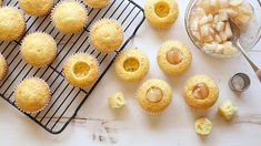 some cupcakes are sitting on a cooling rack next to a bowl of nuts