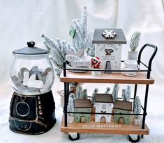 there are two snow globes on top of the small cart and one is filled with miniature houses