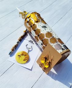 a pair of earrings sitting on top of a wooden table next to a bottle filled with honey