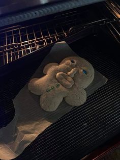 an elephant shaped cookie sitting on top of a sheet of paper in an open oven