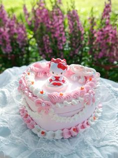 a hello kitty cake with pink frosting and flowers