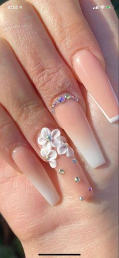 a woman's nails with flowers on them and some glitters in the middle