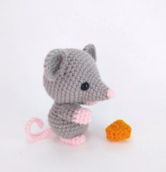 a small crocheted mouse next to a carrot