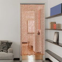 a living room with a couch, bookshelf and sliding glass door that has vertical blinds on it