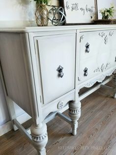 a white painted dresser with drawers and knobs