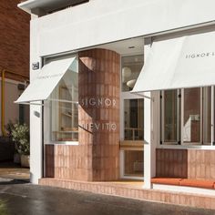 a store front with an awning on the side of it's window display