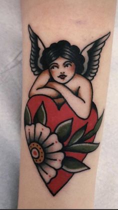 a tattoo with an angel holding a heart and flowers on the side of her arm