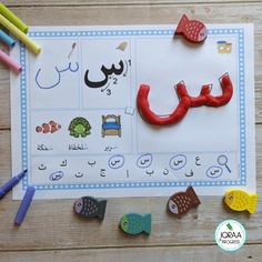 arabic letters and numbers are displayed on a sheet of paper with colored crayons