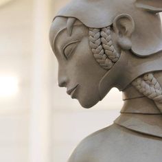 a statue of an egyptian woman with braids in her hair