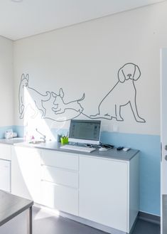 a laptop computer sitting on top of a desk in front of a dog wall decal