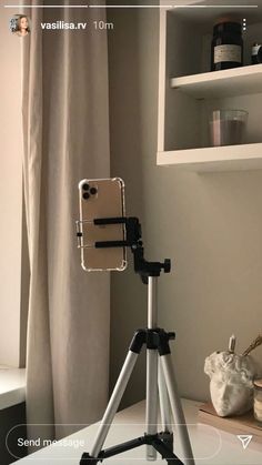 an iphone on a tripod in front of a window with the camera attached to it