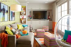 a living room filled with lots of furniture and colorful pillows on top of it's couches