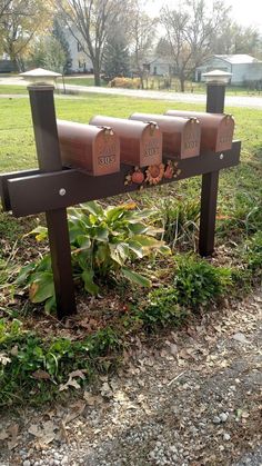 three mailboxes sitting on top of a wooden bench in the middle of a park