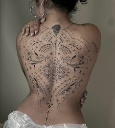 the back of a woman's body is covered in intricate designs and features stars