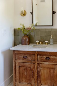 a bathroom vanity with two sinks and a mirror