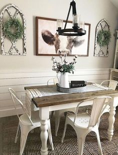 a dining room table with chairs and pictures on the wall