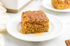 two white plates topped with granola bars on top of a table next to cinnamon sticks