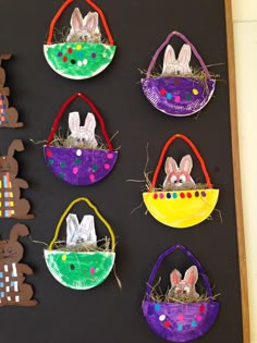 some paper bags with rabbits in them on a black board and easter decorations hanging from the wall