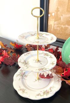 three plates stacked on top of each other in front of a mirror with autumn leaves