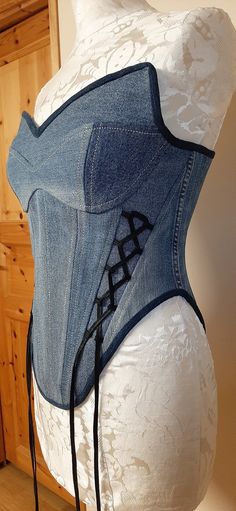 a mannequin wearing a denim corset with letters on it