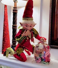 an elf figurine sitting on top of a mantle