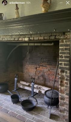 an old brick fireplace with pots and pans on it