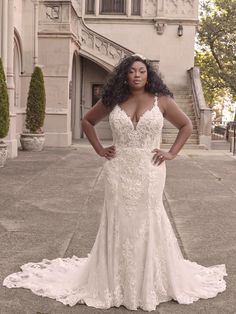 a woman standing in front of a building wearing a wedding dress with an open back