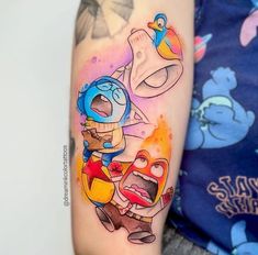 an arm tattoo with cartoon characters on it