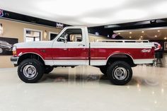 a red and white truck parked in a showroom