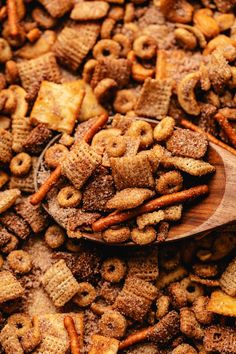 a wooden spoon filled with cereal flakes on top of a pile of other food