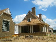 an old brick house is being renovated with new windows and shingles on the roof