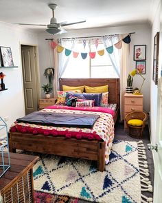 a bed room with a neatly made bed and a rug on the floor next to it