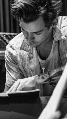 a man sitting at a table writing in a notebook