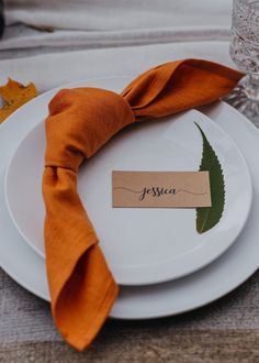 a white plate with an orange napkin and name tag