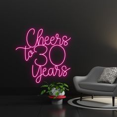 a neon sign that says cheers to 30 years next to a chair and potted plant