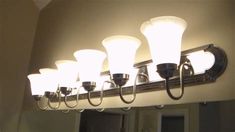 a bathroom light fixture with five lights on the top and four lamps on the bottom