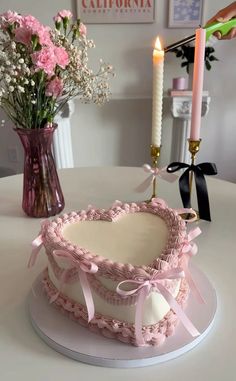 a cake sitting on top of a table next to a vase with flowers in it