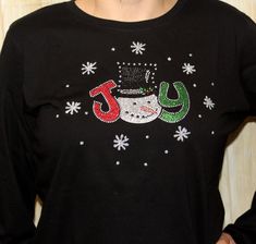 "Rhinestone JOY Snowman Holiday Shirt Bling Ladies Longsleeve T shirt Cute Holiday Snowman!  With Vinyl and Rhinestones.  I hand painted the snowflakes and dots to make it sparkle! ♥ LIMITED AVAILABLE AND NO EXCHANGES OR RETURNS♥ It is pictured on a black 100% Ringspun Cotton ladies Long Sleeve crew shirt.  ♥Closeout Item ♥No Exchanges or Returns ♥Design still available,  just not with paint and glittered snowflakes♥ Width Small-18.38\" Medium-19.38\" Large-21.5\" X-Large-23.63\" 2X-25.75\" Leng Craft Shows, Holiday Snowmen, Tree Shirt, Holiday Shirt, Cute Snowman, Crew Shirt, Holiday Shirts, Winter Season, Cute Shirts