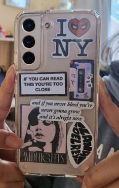 someone holding up their phone case with stickers on it