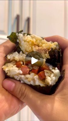 someone is holding up some food in their hand with the video showing them how to make rice and vegetables