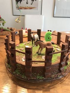 there is a cake that looks like a farm scene with horses and sheep on it