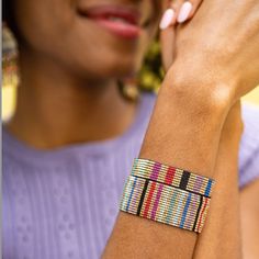 a woman is wearing a colorful bracelet on her wrist