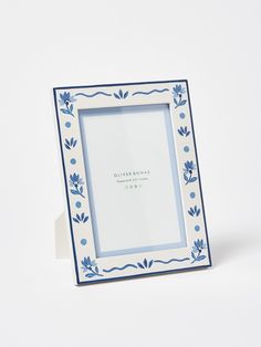 a blue and white photo frame sitting on top of a table