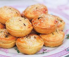 a white plate topped with mini pastries covered in sesame seeds