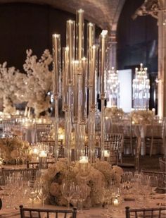 an elegant wedding reception with tall centerpieces and candles