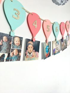 a bunch of pictures hanging on a wall with numbers and balloons attached to the strings