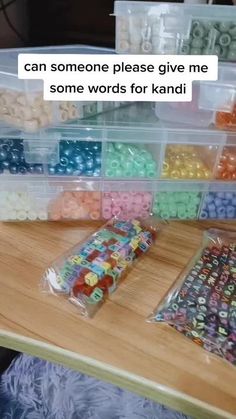 there are many different types of beads in the bins on the table and one is saying, can someone please give me some words for kandi?