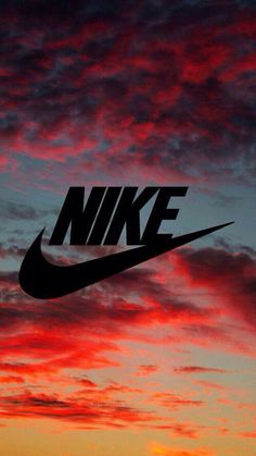 the nike logo is silhouetted against an orange and pink sky with clouds in the background