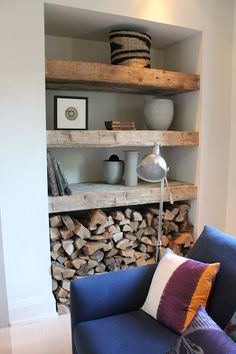 a blue chair sitting in front of a firewood rack